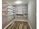 Large walk-in closet with adjustable shelving system and wood-look floors at 4900 Grand Ave, De Leon Springs, FL 32130