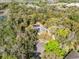 A high aerial view showcases the home's solar panels and screened pool surrounded by lush greenery at 520 Long Lake Ct, Oviedo, FL 32765