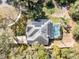 Aerial view of a home with solar panels and screened pool nestled among trees at 520 Long Lake Ct, Oviedo, FL 32765