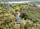 Aerial shot showcases a home with screened pool amid serene woodlands, with views of a nearby lake at 520 Long Lake Ct, Oviedo, FL 32765