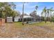 Home exterior features a yard with mature trees, a screened-in pool, and solar panels on the roof at 520 Long Lake Ct, Oviedo, FL 32765