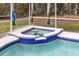 Close up of an in-ground hot tub with tile trim and a partially screened-in lanai at 520 Long Lake Ct, Oviedo, FL 32765