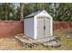 Durable outdoor storage shed, bordered by a brick wall and decorative stones, providing ample space for tools at 520 Long Lake Ct, Oviedo, FL 32765