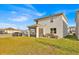 View of the backyard with screened-in lanai and lush lawn, backing onto a row of other houses at 5237 Royal Point Ave, Kissimmee, FL 34746