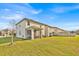 Backyard view showcasing the home's exterior, screened-in lanai, and expansive green lawn at 5237 Royal Point Ave, Kissimmee, FL 34746