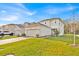 Two-story home featuring a two-car garage, brick driveway, well-manicured lawn, and neutral-colored exterior at 5237 Royal Point Ave, Kissimmee, FL 34746