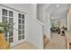 Bright foyer featuring a staircase, tile flooring, and a decorative glass door leading to an office space at 5237 Royal Point Ave, Kissimmee, FL 34746