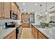 Stylish kitchen featuring wood cabinets, stainless steel appliances, and elegant countertops at 5237 Royal Point Ave, Kissimmee, FL 34746