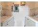 Inside laundry room featuring a washer and dryer, electrical panel, and wire shelving at 5550 E Michigan St # 3309, Orlando, FL 32822