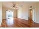 Spacious living room featuring hardwood floors, ceiling fan, and sliding glass door at 5550 E Michigan St # 3309, Orlando, FL 32822