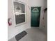 Green front door with window showing partial kitchen view and a mounted fire extinguisher at 570 Cranes Way # 246, Altamonte Springs, FL 32701