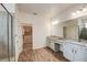 Bright bathroom featuring dual vanities, spacious shower, and a large walk-in closet with custom shelving at 603 Fortuna Dr, Davenport, FL 33837