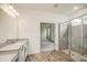 Bright bathroom featuring a tiled walk-in shower, dual vanities, and a view into the adjacent bedroom at 603 Fortuna Dr, Davenport, FL 33837