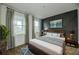 Cozy bedroom features wood floors, stylish wall art, and plenty of natural light from the large windows at 603 Fortuna Dr, Davenport, FL 33837