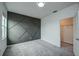 A carpeted bedroom with a gray accent wall, a window, and an open closet door at 603 Fortuna Dr, Davenport, FL 33837
