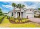 Beautiful home exterior featuring lush landscaping, manicured lawn, and a spacious two-car garage at 603 Fortuna Dr, Davenport, FL 33837