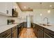 Modern kitchen boasts stainless appliances, white cabinets, granite counters, and wood-look tile floors at 603 Fortuna Dr, Davenport, FL 33837