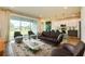 Elegant living room with modern furniture, large windows offering backyard views, and seamless flow to the kitchen at 603 Fortuna Dr, Davenport, FL 33837