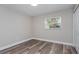 A spare bedroom featuring neutral walls, wood-look floors, a window, and a closet at 605 Hill Ave, Ocoee, FL 34761