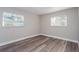 A bedroom with natural light, neutral walls, and wood-look flooring at 605 Hill Ave, Ocoee, FL 34761