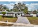 Charming single-story home featuring a well-manicured lawn, stone accents, and a spacious driveway at 605 Hill Ave, Ocoee, FL 34761