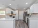 Well-lit kitchen with white cabinetry, stainless steel appliances, island, and sleek marble countertops at 605 Hill Ave, Ocoee, FL 34761