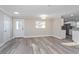 Bright living room featuring new hard surface flooring, a window, and a glass door to the exterior at 605 Hill Ave, Ocoee, FL 34761