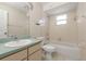 Bright bathroom featuring a tub with shower, sink, and light neutral tile walls at 6385 Royal Tern St, Orlando, FL 32810