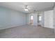 Spacious bedroom with gray carpet flooring, light blue walls, fan, and closet at 6385 Royal Tern St, Orlando, FL 32810