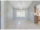 Elegant dining area with a bay window and pendant lighting, complemented by sleek tile floors and neutral tones at 6385 Royal Tern St, Orlando, FL 32810