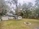 Spacious backyard featuring mature trees, fire pit, and a shed at 701 S Delaware Ave, Deland, FL 32720