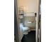 Compact bathroom with a toilet, sink, and storage shelving, maximizing space efficiency at 701 S Delaware Ave, Deland, FL 32720