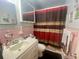 Cozy bathroom with a sink, toilet and bathtub with red patterned shower curtain at 701 S Delaware Ave, Deland, FL 32720