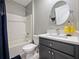 Bathroom featuring a single sink vanity, a bathtub with a shower, and a round mirror for a modern touch at 756 Kindred Ln, Auburndale, FL 33823