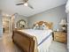 Spacious bedroom featuring a ceiling fan, tiled floors, and an intricately carved wooden bed frame with an ornate dresser at 756 Kindred Ln, Auburndale, FL 33823