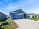 Lovely one-story blue home with a spacious driveway and nice landscaping at 756 Kindred Ln, Auburndale, FL 33823