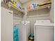 Functional laundry area with modern washer, dryer, shelving, and additional storage space at 756 Kindred Ln, Auburndale, FL 33823