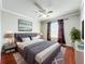 Bedroom featuring hardwood floors, a grey bed set, and decorative window curtains at 8438 Diamond Cove Cir, Orlando, FL 32836