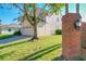 View of the home's side exterior, featuring a well-manicured lawn and brick pillar entry at 8438 Diamond Cove Cir, Orlando, FL 32836