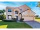 Inviting two-story home featuring a three-car garage and well-maintained landscaping at 8438 Diamond Cove Cir, Orlando, FL 32836