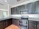 Kitchen with stainless steel appliances, granite countertops, and dark wood cabinets at 8438 Diamond Cove Cir, Orlando, FL 32836