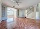 Open-concept living room featuring tile floors, ceiling fan, and staircase to the upper level at 8438 Diamond Cove Cir, Orlando, FL 32836