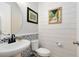 Charming powder room featuring a pedestal sink with patterned backsplash and shiplap accent wall at 8803 Peachtree Park Ct, Windermere, FL 34786