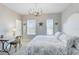 Bright bedroom featuring a chandelier, two windows, a writing desk and an ensuite bathroom at 8803 Peachtree Park Ct, Windermere, FL 34786