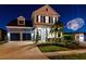 Charming two-story home with landscaped yard and three car garage illuminated for an evening fireworks display at 8803 Peachtree Park Ct, Windermere, FL 34786