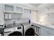 Well-organized laundry room with a stainless steel washer and dryer with sink and storage cabinets at 8803 Peachtree Park Ct, Windermere, FL 34786