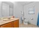 Well-lit bathroom with wood vanity, marble countertops, toilet, and tiled floors at 921 Emerald Green Ct, Kissimmee, FL 34746