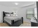 Simple bedroom with gray bedding, a dark wood bed frame, and natural light at 921 Emerald Green Ct, Kissimmee, FL 34746