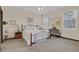 Cozy bedroom showcasing an ornate metal bed frame, neutral carpeting and bright natural light at 10286 Cypress Knee Cir, Orlando, FL 32825