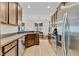 Well-lit kitchen features stainless steel appliances, tile flooring, and sleek brown cabinetry at 10286 Cypress Knee Cir, Orlando, FL 32825